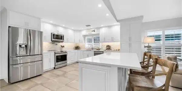 Image 3: Kitchen with stainless steel appliances, light countertops, backsplash, recessed lighting, and a sink