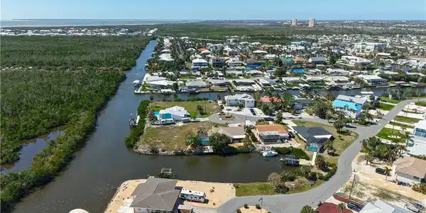 Image 4: Aerial overview of property's location featuring a nearby body of water and nearby suburban area