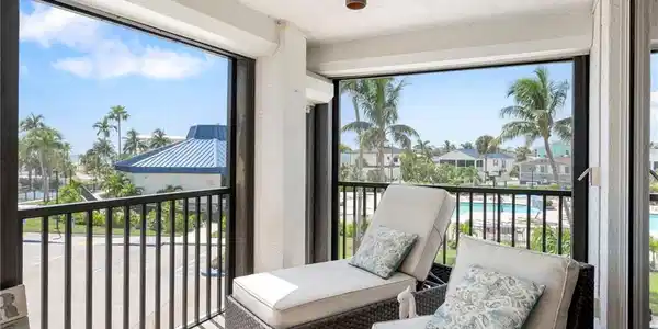 Image 3: Balcony featuring a sunroom and view of pool