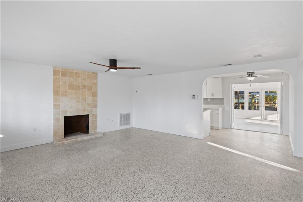 Image 2: Bright and open living area with a cozy fireplace and coastal charm.