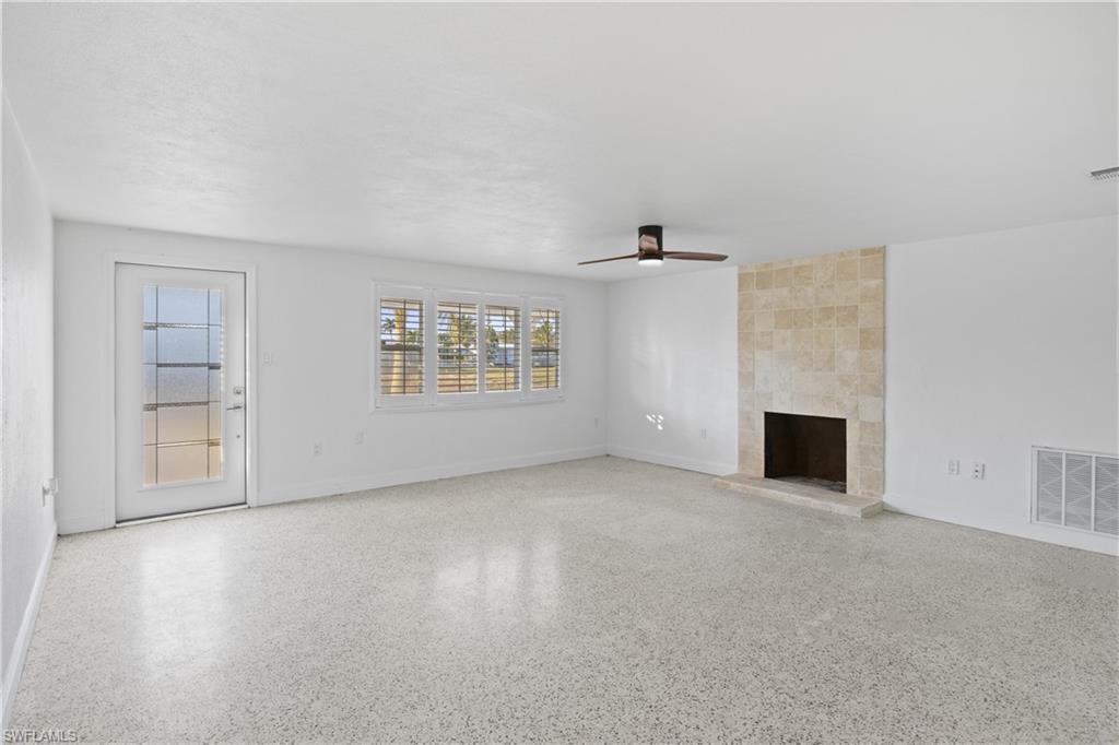 Image 3: Warm living room featuring a fireplace and inviting Old-Florida character.