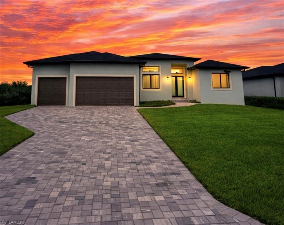 Image 1: Prairie-style home with a front yard, stucco siding, and decorative driveway (Rendered photo)