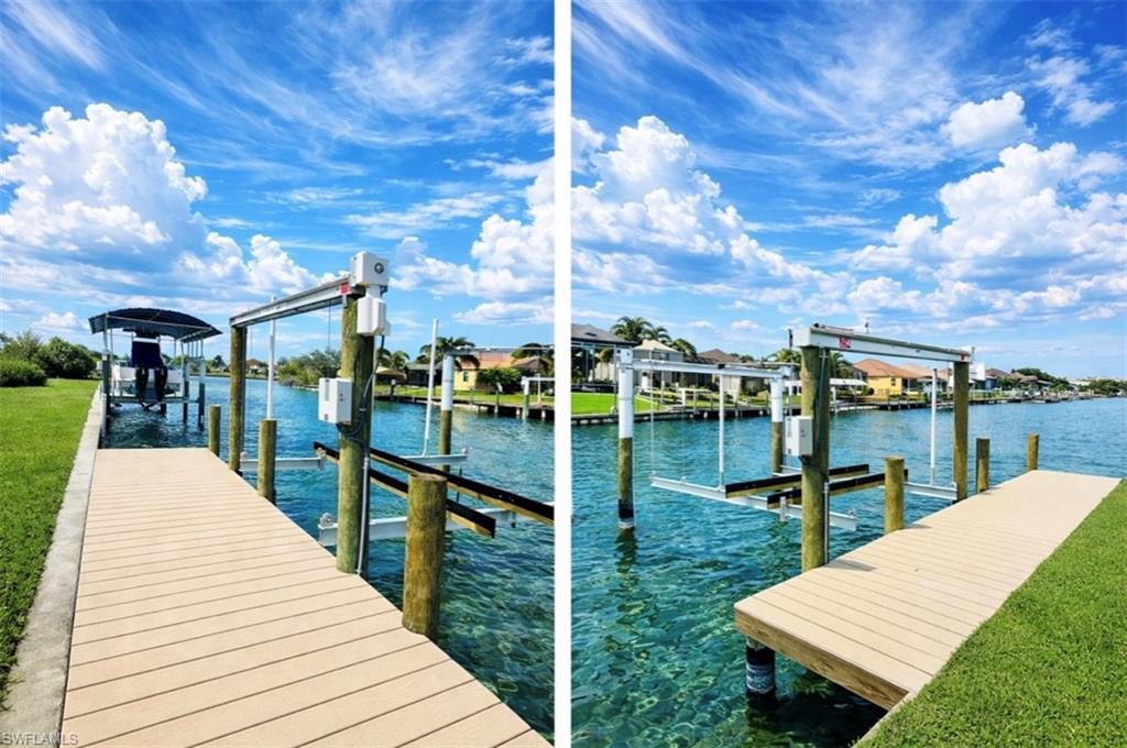 Image 4: Dock featuring boat lift, a water view, and a yard