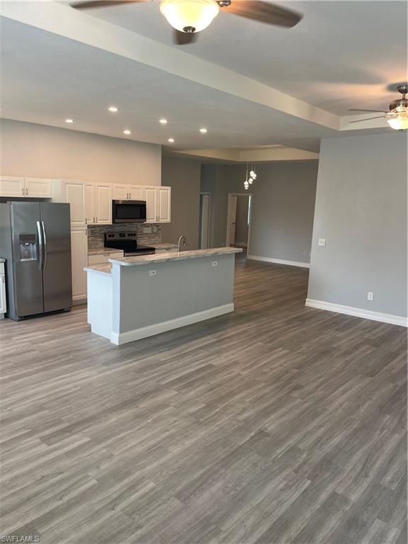 Image 4: Kitchen with ceiling fan, fridge, white cabinetry, dark wood-style flooring, and recessed lighting