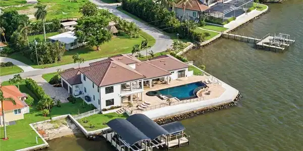 Image 3: Set across two private homesites, this extraordinary waterfront estate offers a rare sense of seclusion and privacy, framed by unobstructed views of Southwest Florida&rsquo;s spectacular sunsets. Each evening, the sky becomes a breathtaking masterpiece, creating an unparalleled backdrop for refined waterfront living.