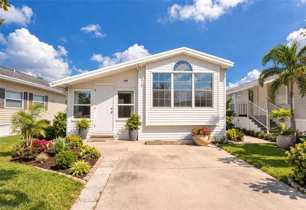 Image 1: Manufactured / mobile home featuring entry steps and a front lawn