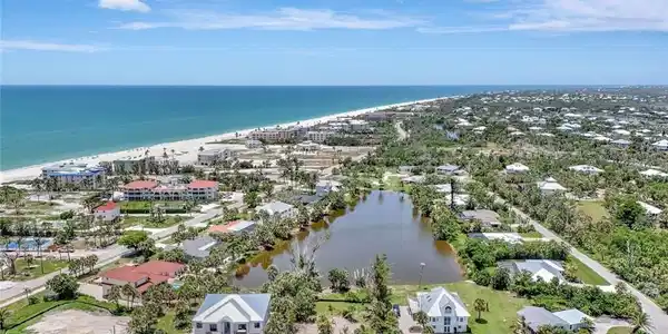 Image 2: Aerial view of residential area featuring expansive beach