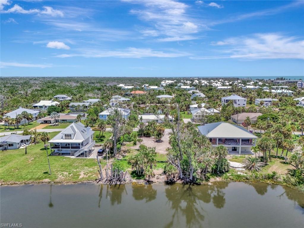 Image 3: Aerial perspective of suburban area featuring a nearby body of water
