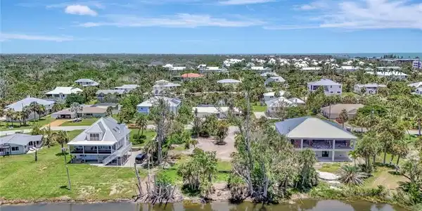 Image 3: Aerial perspective of suburban area featuring a nearby body of water