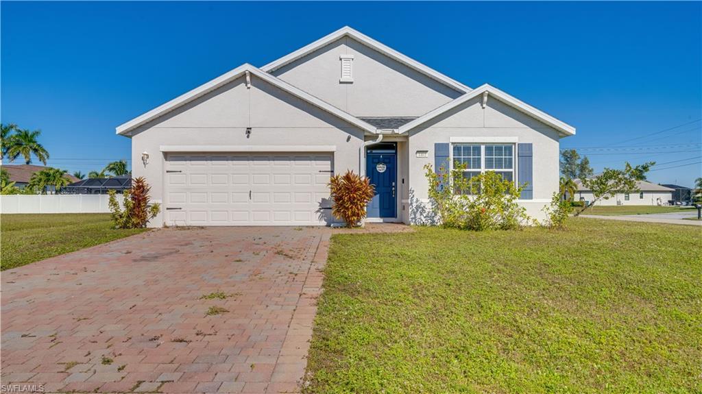 Image 2: Ranch-style home featuring stucco siding, decorative driveway, and an attached garage