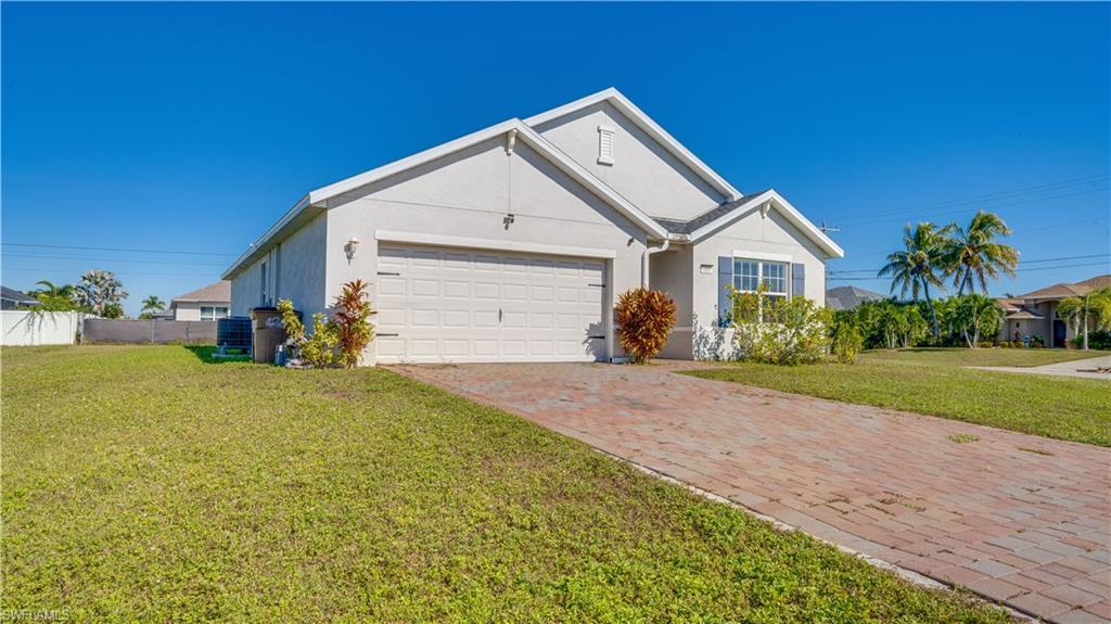 Image 3: Ranch-style house with stucco siding, decorative driveway, and a garage