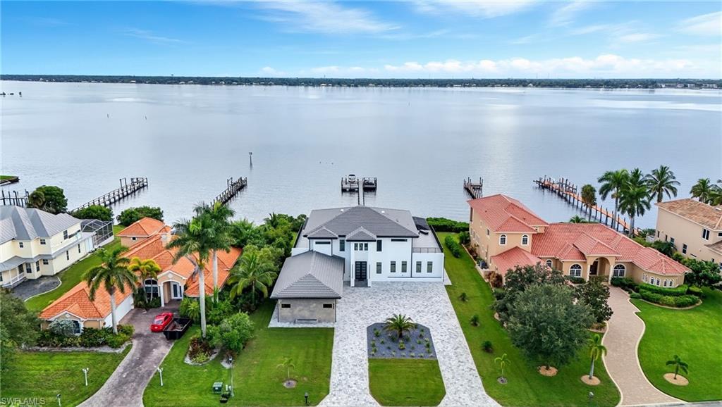 Image 4: Aerial perspective of suburban area featuring a nearby body of water