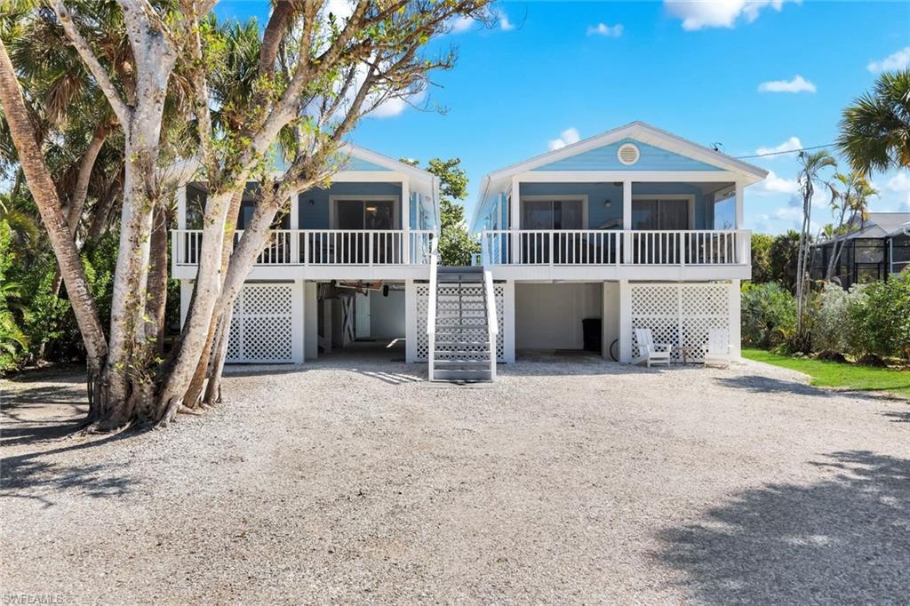 Image 3: Coastal home featuring a carport, a deck, and driveway