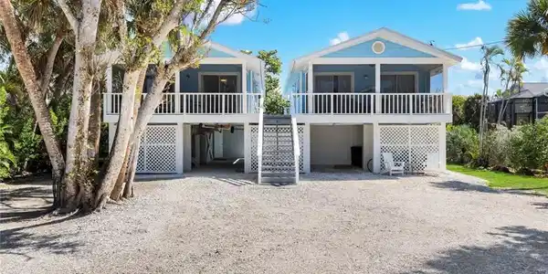 Image 3: Coastal home featuring a carport, a deck, and driveway