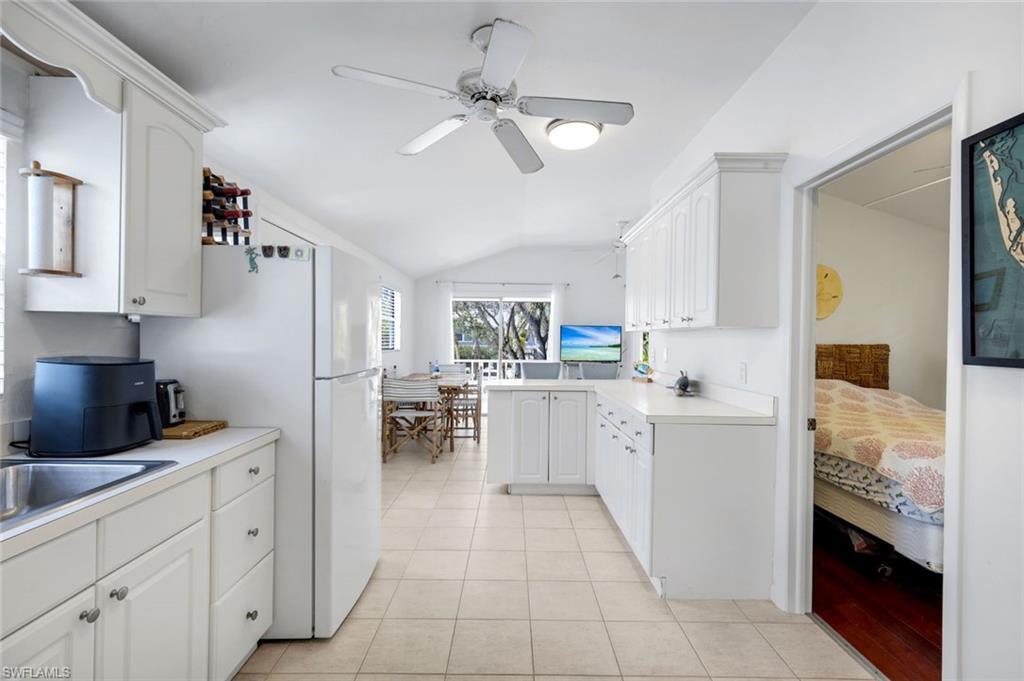 Image 4: Kitchen featuring light countertops, white cabinetry, vaulted ceiling, a peninsula, and ceiling fan