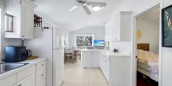 Image 4: Kitchen featuring light countertops, white cabinetry, vaulted ceiling, a peninsula, and ceiling fan