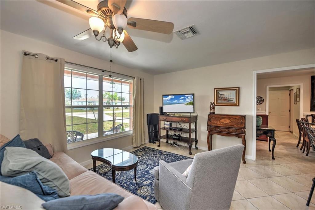 Image 4: Living room with visible vents, a ceiling fan, baseboards, and light tile patterned floors