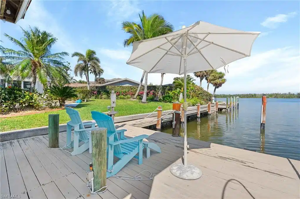 Image 1: Dock area with a water view and a lawn Virtually enhanced image