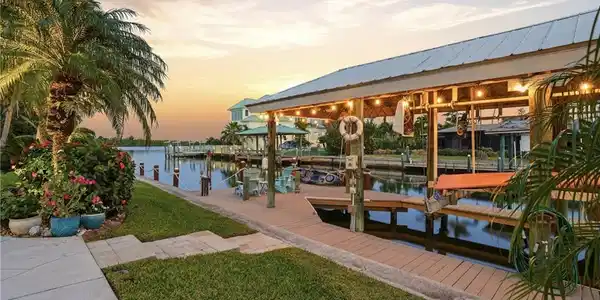 Image 3: Dock featuring boat lift, a water view, and a yard -Virtually enhanced image