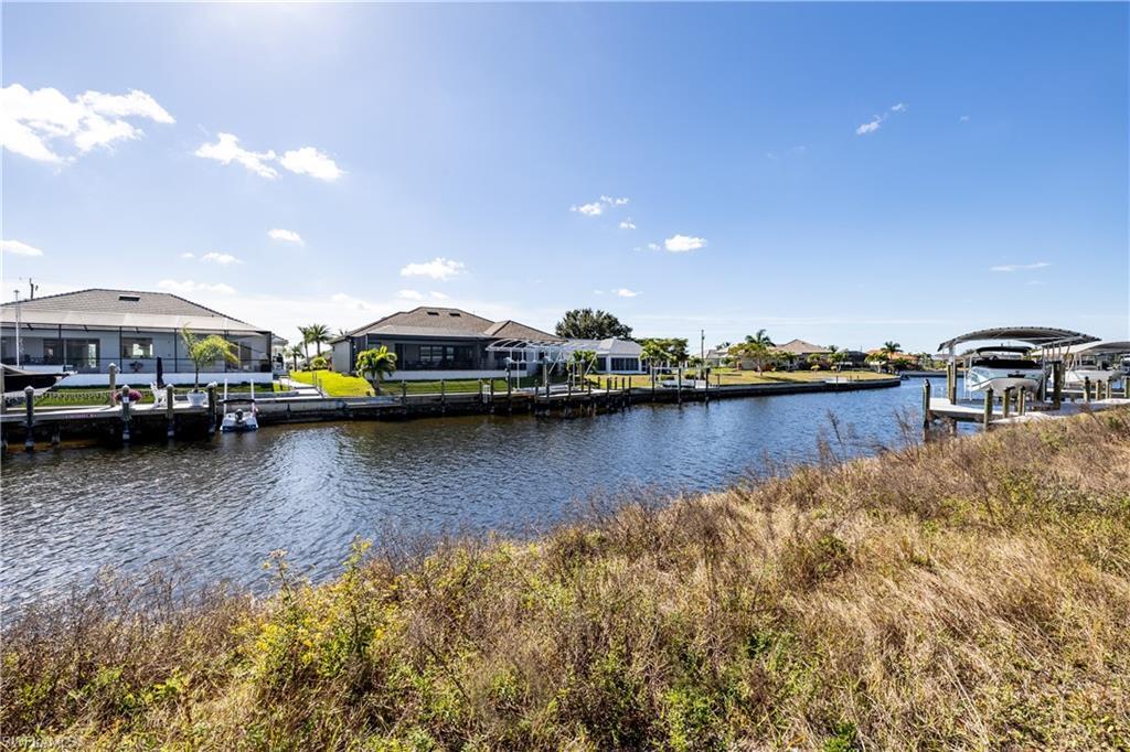 Image 2: Dock featuring a residential view, a water view, and boat lift