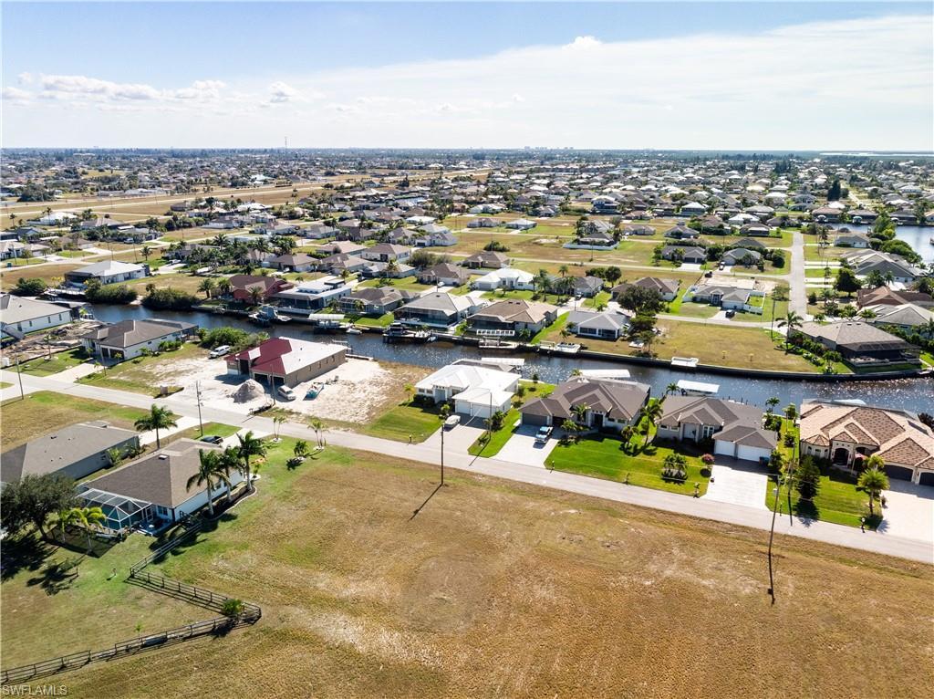 Image 4: Aerial view of residential area featuring a nearby body of water