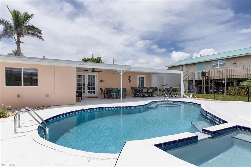 Image 3: Freeform swimming pool with integrated spa and surrounding white concrete deck