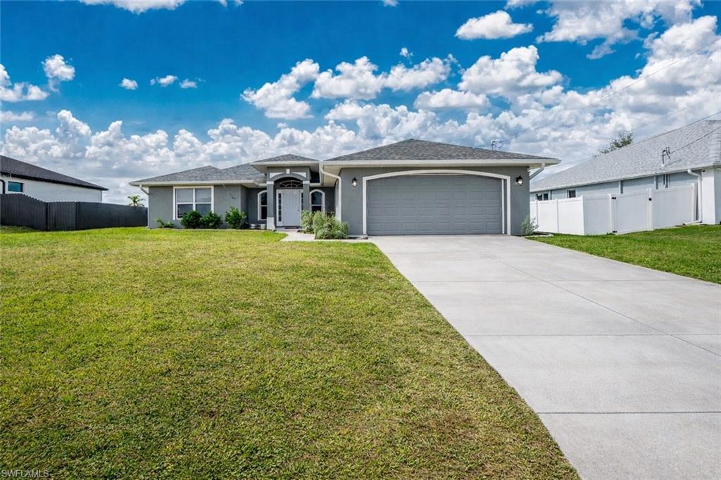 Image 1: Ranch-style house featuring an attached garage, stucco siding, and driveway