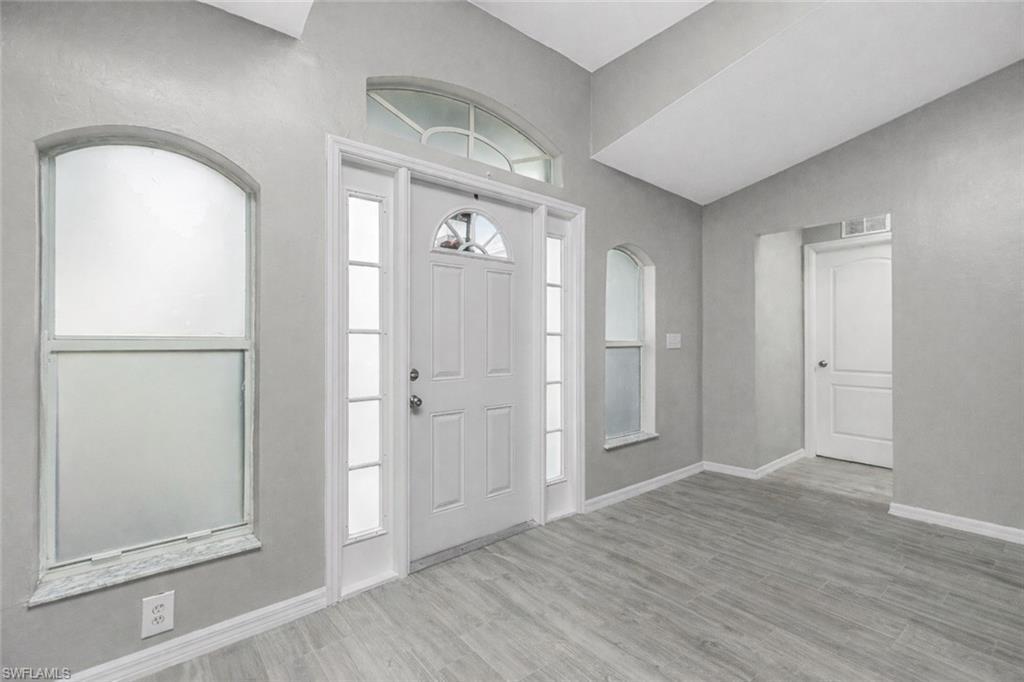 Image 3: Entrance foyer featuring baseboards and light wood-type flooring