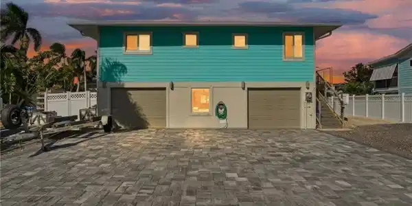 Image 3: Coastal home featuring decorative driveway, stairway, and an attached garage - Virtually Edited Image