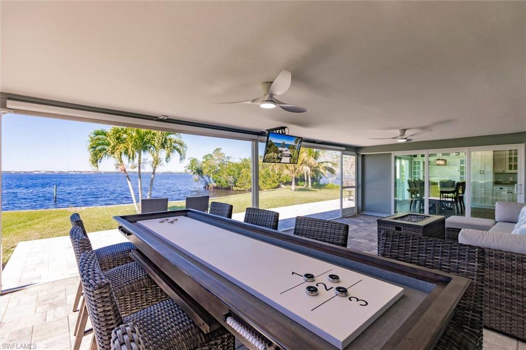 Image 3: View of patio with an outdoor living space with a fire pit and ceiling fan