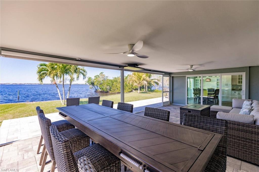 Image 4: View of patio / terrace with a ceiling fan, outdoor dining space, a water view, and an outdoor living space