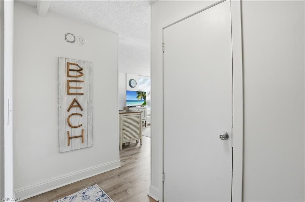 Image 4: Entryway featuring light wood-finish flooring, white baseboards, and a white interior door with a chrome knob - Virtually Edited Image