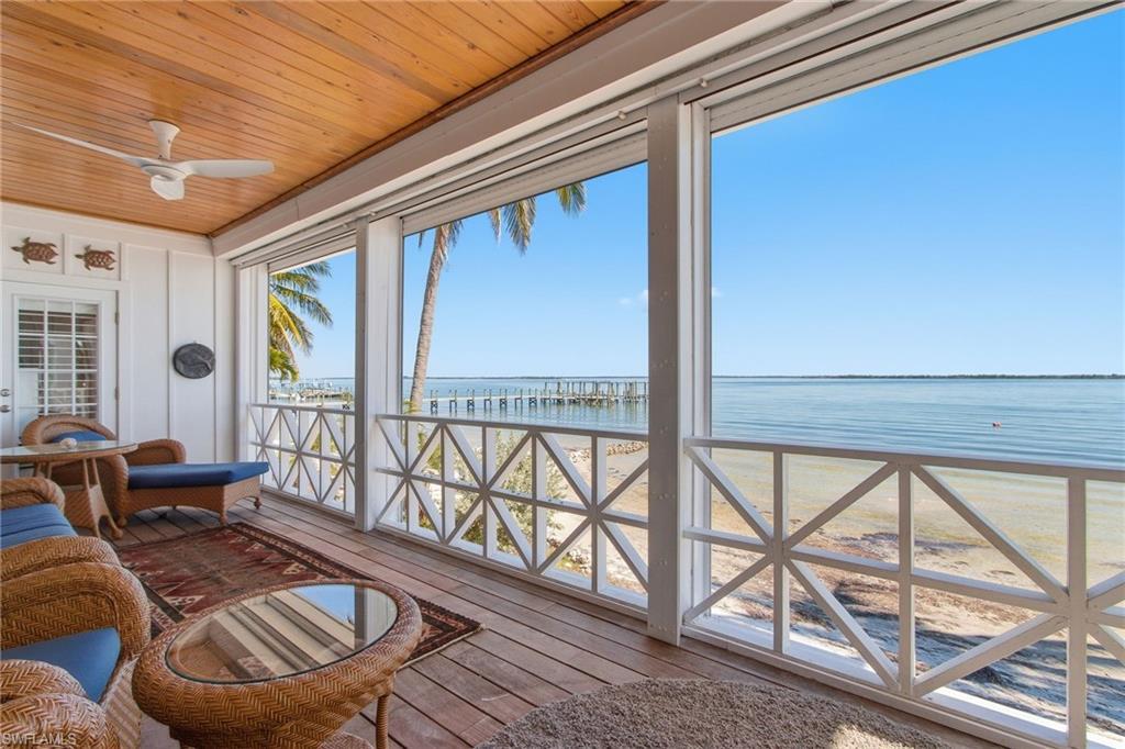 Image 2: Sunroom with view of water and beach, wood ceiling, and hardwood / wood-style flooring