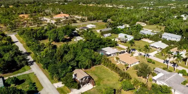 Image 3: Aerial perspective showcasing a residential area with diverse architectural styles, surrounded by abundant natural foliage