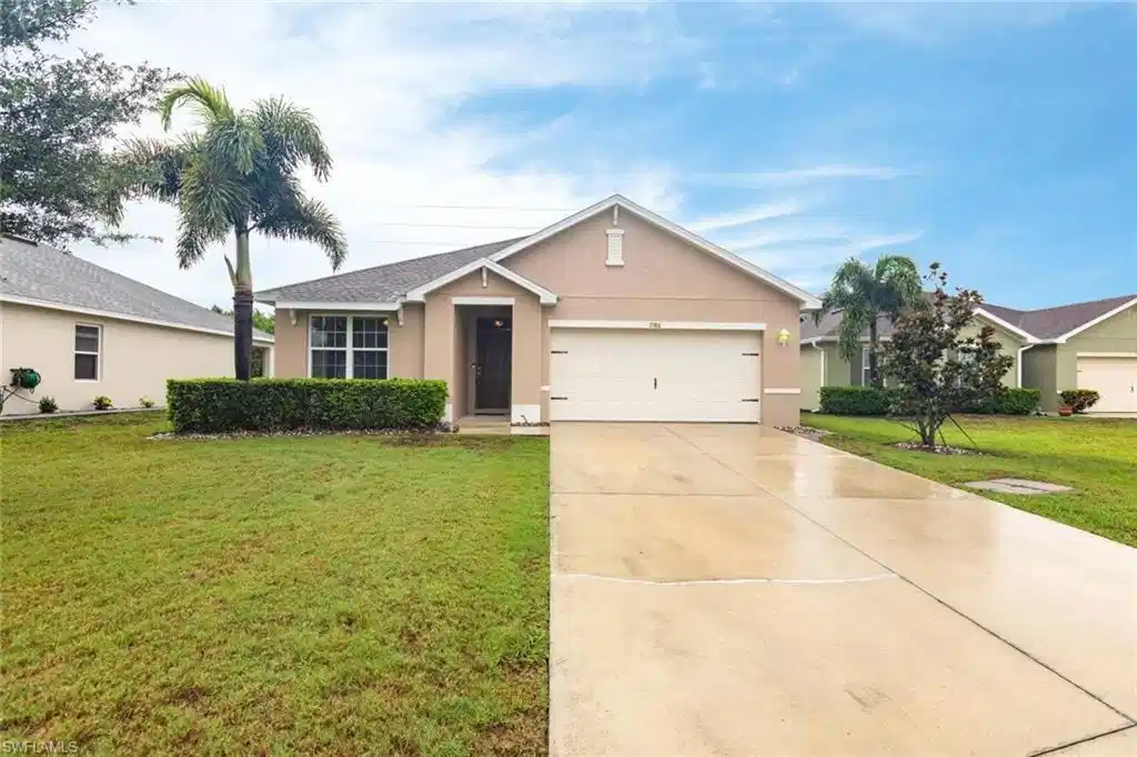 Image 1: Ranch-style house featuring stucco siding, a front yard, driveway, and a garage