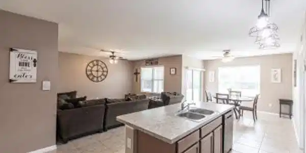 Image 3: Kitchen featuring light countertops, ceiling fan, a kitchen island with sink, and open floor plan