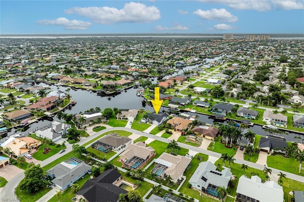 Image 4: Aerial view of property and surrounding area with a large body of water and nearby suburban area