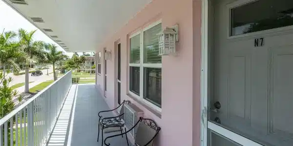 Image 2: Covered exterior balcony with pale pink stucco facade