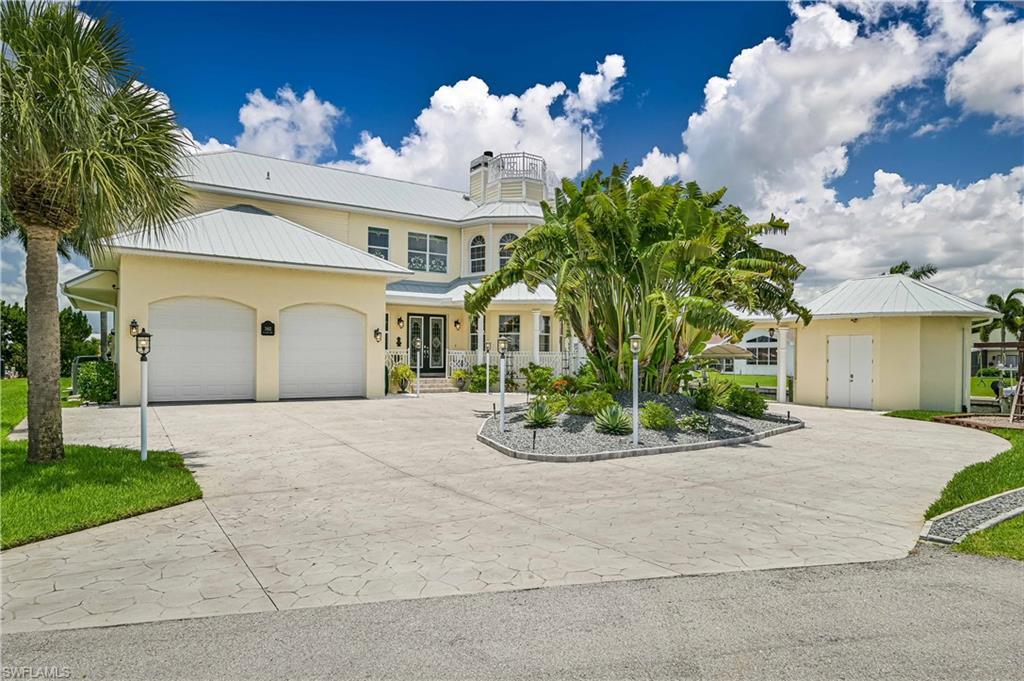 Image 2: View of front of home featuring decorative driveway, metal roof, an attached garage, and stucco siding