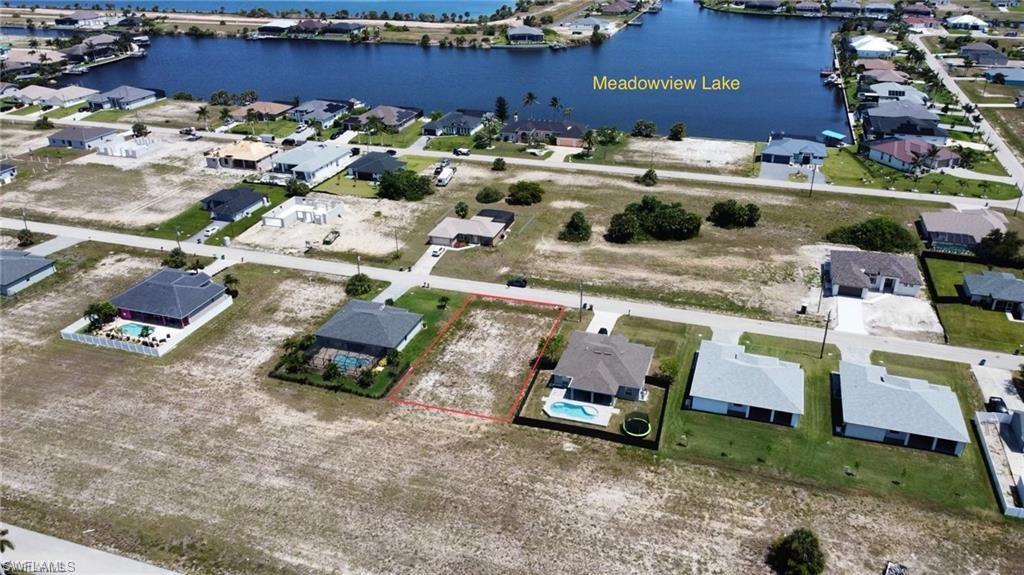 Image 4: Aerial view of residential area with a nearby body of water and property parcel outlined
