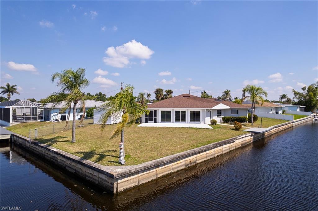 Image 4: Rear view of house featuring a yard, a water view, and fence