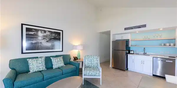 Image 2: Living room with high vaulted ceiling, bar with sink, and light tile patterned floors