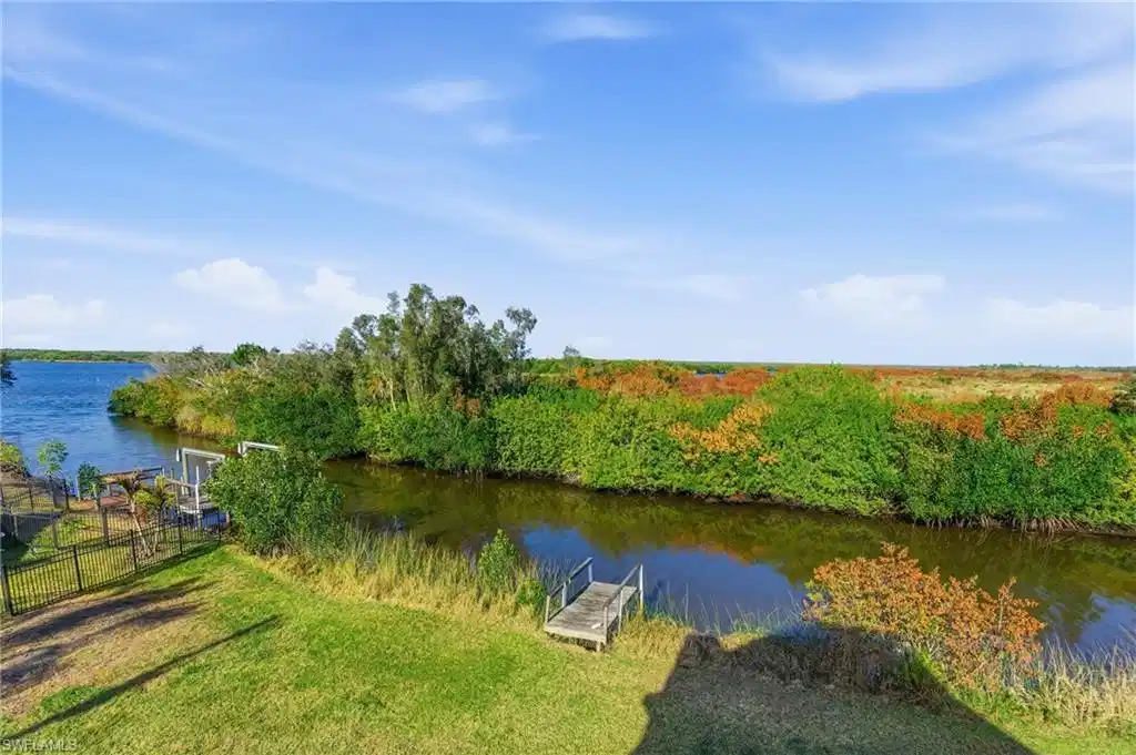 Image 1: Dock with a water view and a lawn