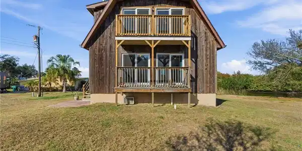 Image 2: Rear view of house with a lawn and a porch
