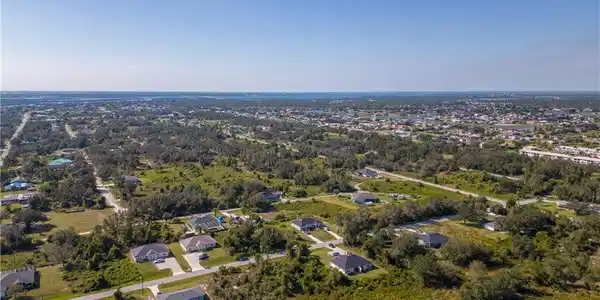 Image 3: Aerial view of property and surrounding area with nearby suburban area