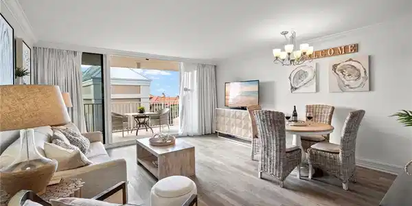 Image 2: Spacious living room with sleeper sofa, sitting chair with ottoman, dining for 4, custom drapes