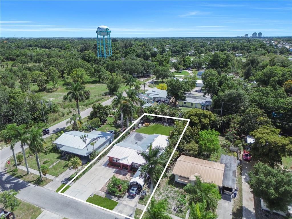 Image 3: Aerial property overview featuring a red-sided structure with a light-colored roof