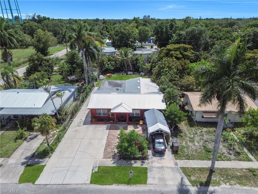 Image 4: Single-story residence featuring a red exterior and a white metal roof