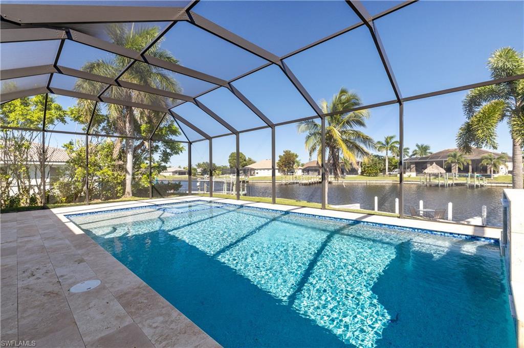 Image 2: Outdoor pool with a water view, a sunroom, a lanai, and a dock