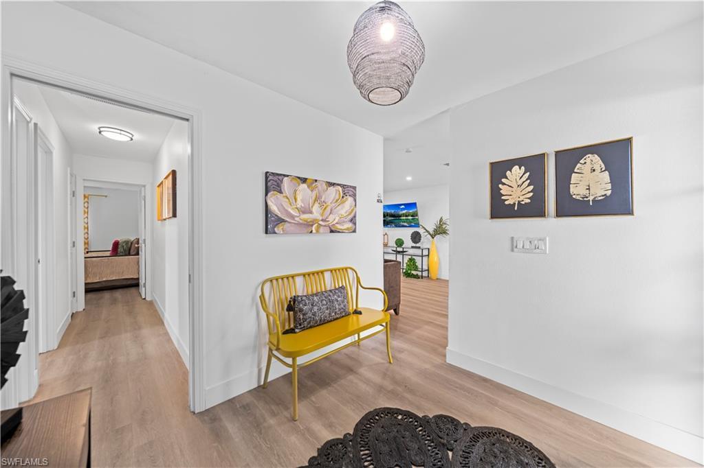 Image 4: Entryway featuring wood-finish flooring, white baseboards, and a woven pendant light fixture